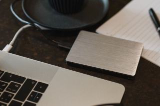 Disque dur externe et cartes mémoire posés près d'un ordinateur portable